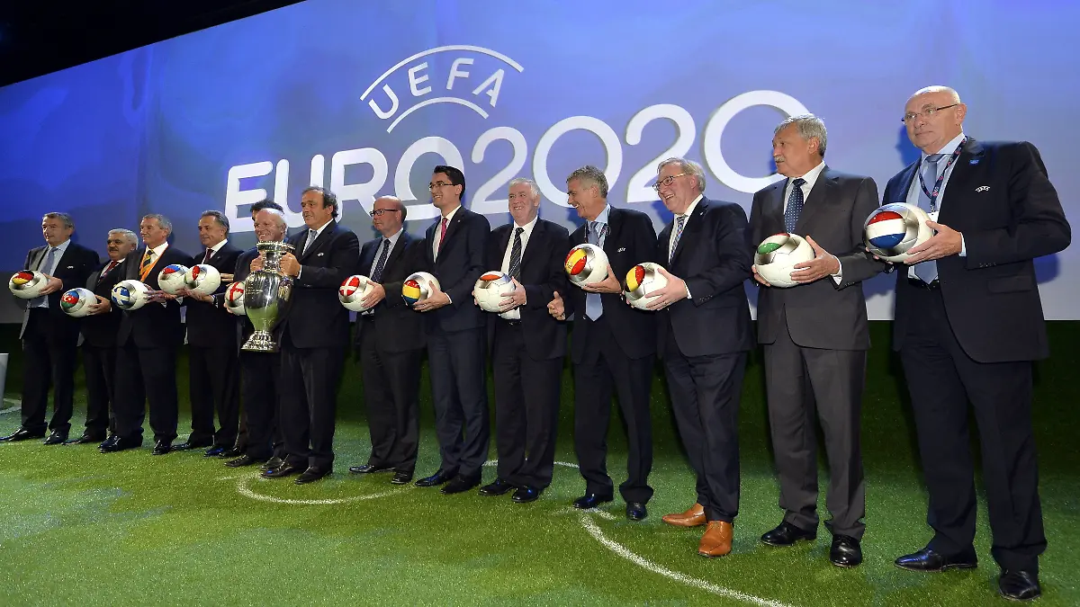 Michel-Platini-mit-Pokal-inmitten-von-Vertretern-der-Gastgebernationen
