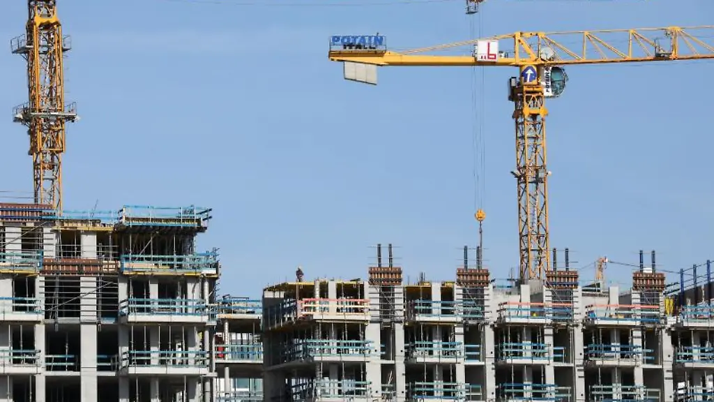 Kraene-stehen-auf-einer-Baustelle-fuer-Wohnhaeuser