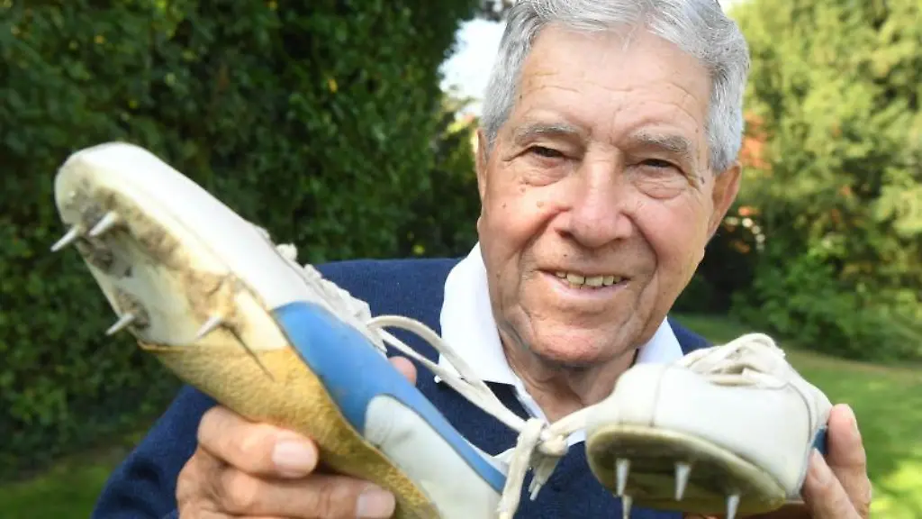Heinz-Fuetterer-Ex-Weltrekordler-ueber-100-Meter-haelt-Laufschuhe-von-sich-in-den-Haenden-die-aus-dem-Jahr-1957-stammen