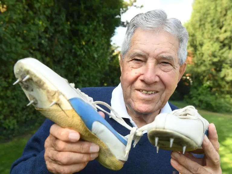 Heinz-Fuetterer-Ex-Weltrekordler-ueber-100-Meter-haelt-Laufschuhe-von-sich-in-den-Haenden-die-aus-dem-Jahr-1957-stammen