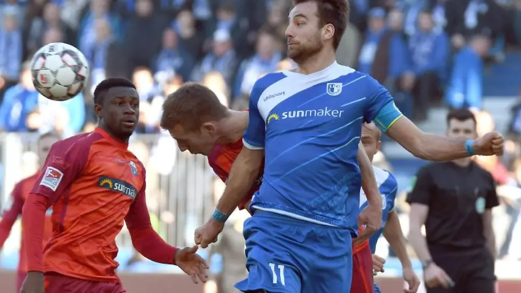 Magdeburgs-Christian-Beck-r-und-Paderborns-Uwe-Huenemeier-und-Jamilu-Collins-l-kaempfen-um-den-Ball
