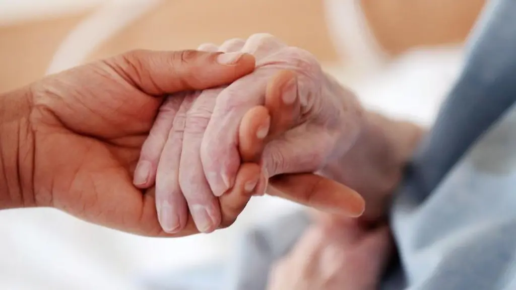 Eine-Pflegerin-haelt-die-Hand-einer-Bewohnerin-einer-Altenheims