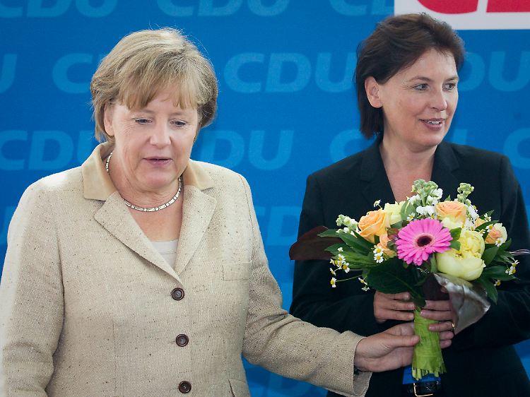 Nicht besonders erfreut: Kanzlerin Merkel überreicht Bremens CDU-Spitzenkandidatin Rita Mohr-Lüllmann einen Blumenstrauß.
