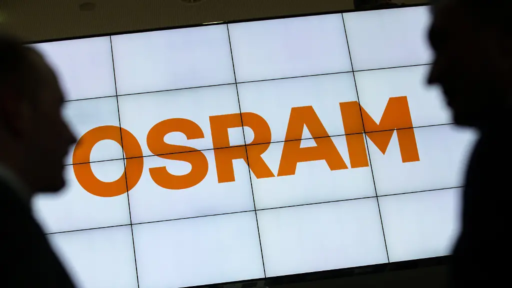 ARCHIV-Zwei-Maenner-unterhalten-sich-am-16-02-2016-auf-der-Hauptversammlung-der-Osram-Licht-AG-im-Internationalen-Congress-Center-Muenchen-ICM-in-Muenchen-Bayern-im-Vordergrund-einer-Monitorwand-auf-der-das-Logo-von-Osram-dargestellt-wird-Foto-Matthias-Balk-dpa-zu-dpa-Handelsblatt-Chinesische-Firmen-wollen-Osram-uebernehmen-vom-29-09