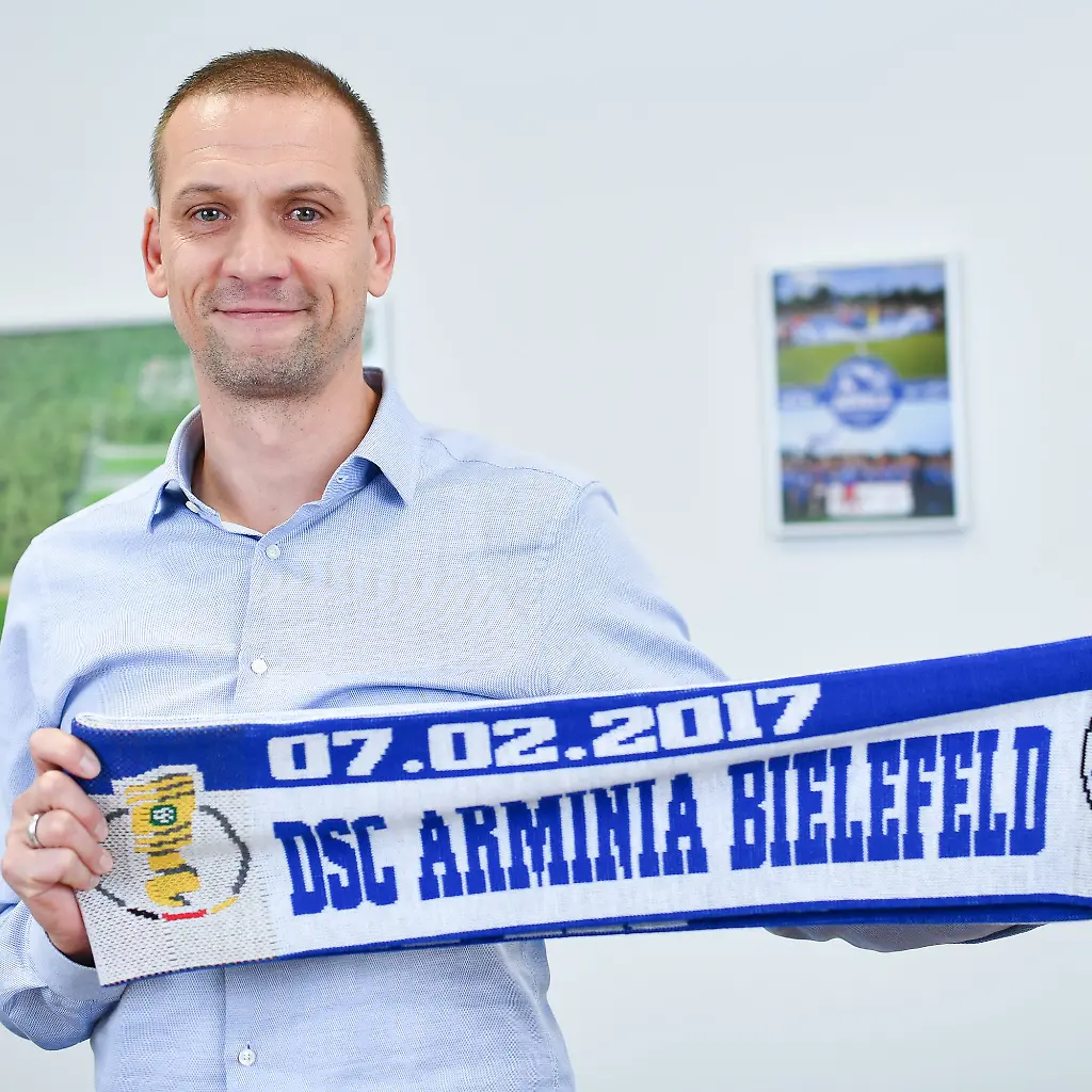 Der-Trainer-des-Fussball-Regionalligisten-FC-Astoria-Walldorf-Matthias-Born-haelt-am-31-01-2017-in-Walldorf-Baden-Wuerttemberg-in-der-Geschaeftsstelle-des-Vereins-einen-eigens-fuer-das-kommende-DFB-Pokal-Achtelfinale-entworfenen-Fanschal-in-den-Haenden-Walldorf-spielt-am-07-02-im-Achtelfinale-des-DFB-Pokals-gegen-Arminia-Bielefeld-zu-dpa-Training-erst-nach-Feierabend-Walldorf-hofft-auf-naechsten-Pokal-Coup-vom-06-02