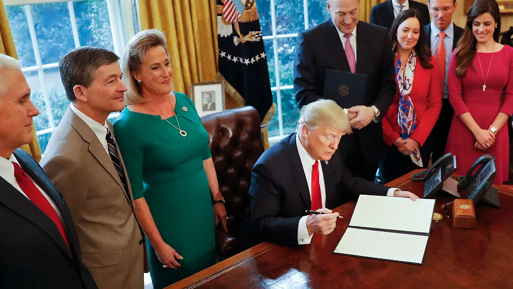 President-Donald-Trump-prepares-to-sign-an-executive-order-in-the-Oval-Office-of-the-White-House-in-Washington-Friday-Feb-3-2017-Trump-signed-an-executive-order-that-will-direct-the-Treasury-secretary-to-review-the-2010-Dodd-Frank-financial-oversight-law-which-reshaped-financial-regulation-after-2008-2009-crisis-At-left-is-Vice-President-Mike-Pence