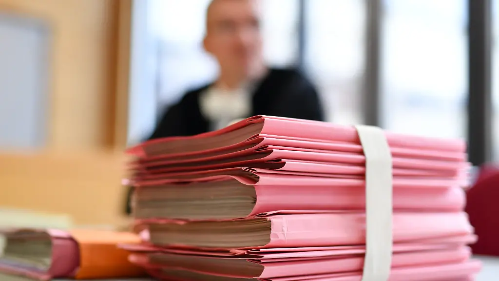 Ein-Staatsanwalt-sitzt-am-20-12-2016-in-Kaiserslautern-Rheinland-Pfalz-im-Landgericht-hinter-einem-Stapel-Akten-Eine-36-Jahre-alte-Mutter-eines-fuenfjaehrigen-Maedchens-und-ein-befreundetes-Paar-sollen-durch-Nichtstun-den-Tod-des-Kindes-verursacht-haben-zu-dpa-Mordprozess-um-Tod-eines-Kindes-Mutter-und-Bekannte-vor-Gericht-vom-20-12