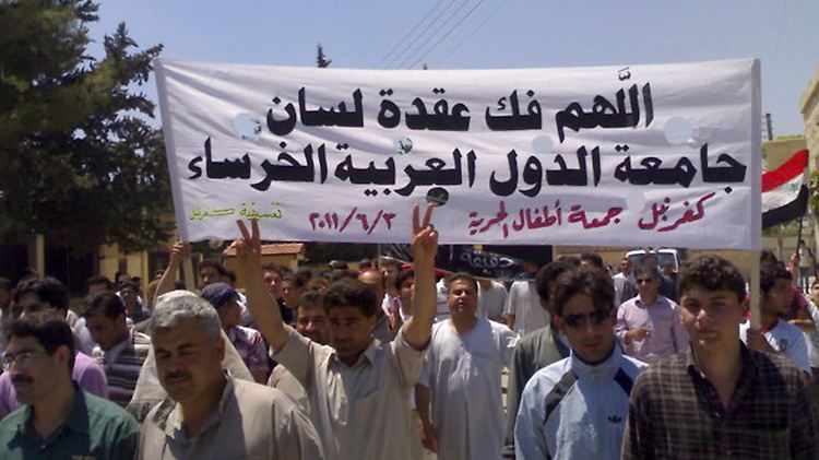 Syrische Demonstranten marschieren durch das Dorf Kfar-Nebel. "Möge Gott die Stille des der Arabischen Liga beenden", steht sinngemäß auf dem Banner.
