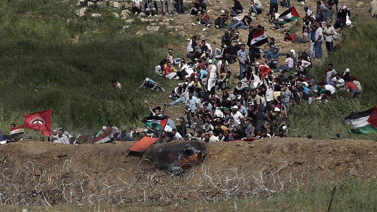 Palästinensische Demonstranten gehen in Deckung, nachdem israelische Soldaten auf den Golanhöhen das Feuer eröffnet haben.