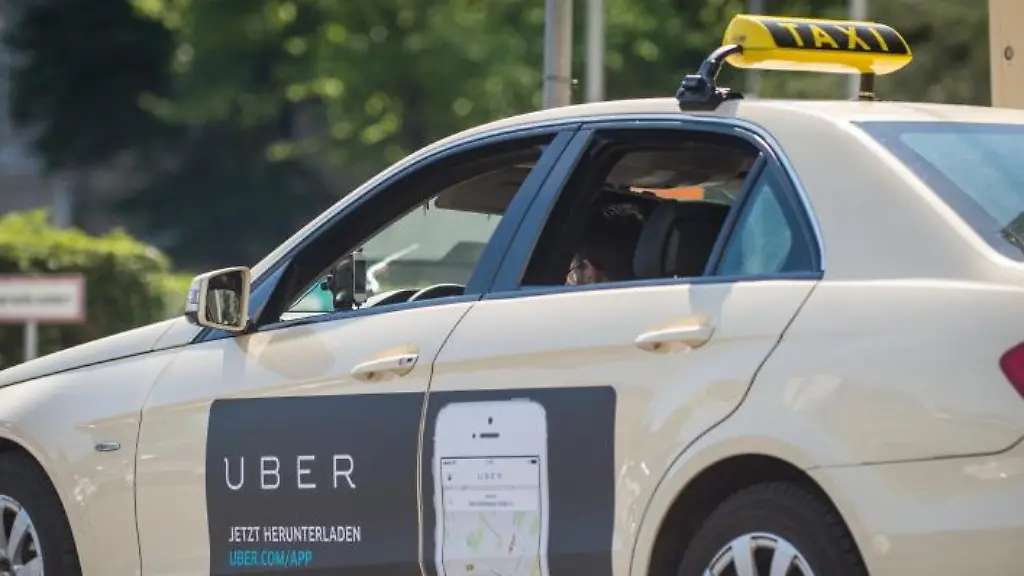Ein-Taxi-mit-Werbung-der-App-Uber-in-Berlin