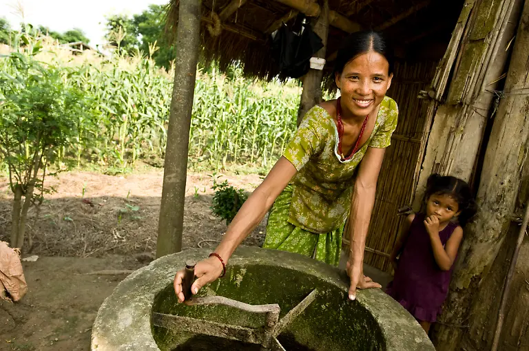 A-woman-turns-the-manure-stirrer-outside-her-home-in-a-bio-gas-village-on-the-outskirts-of-Chitwan-National-Park-Nepal-Only-to-be-used-in-conjunction-with-explicitly-mentioning-WWF-and-World-Heritage-Campaign