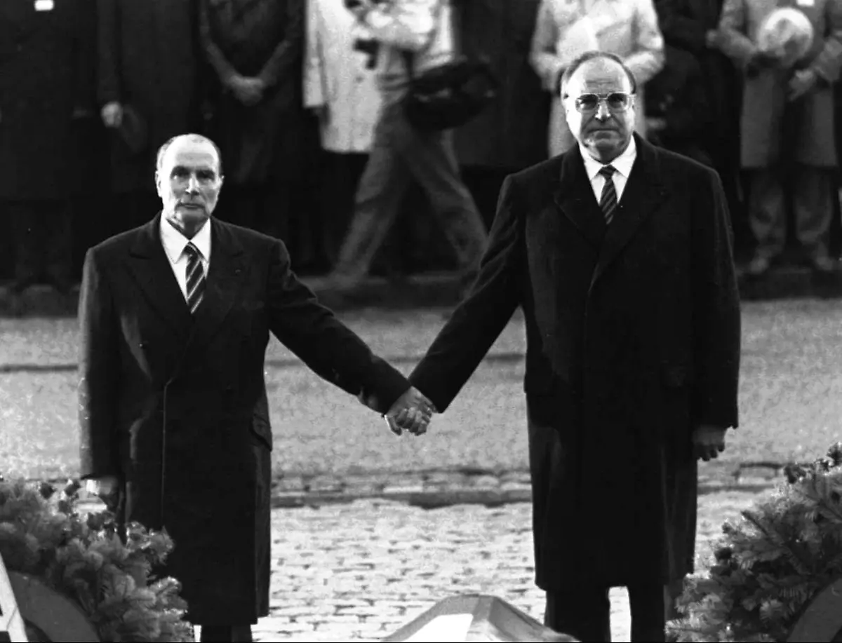 27-Late-French-President-Francois-Mitterrand-and-German-Chancellor-Helmut-Kohl-stand-hand-in-hand-as-they-listen-to-their-respective-national-anthems-during-a-French-German-reconciliation-ceremon