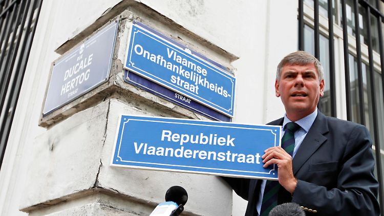 Filip Dewinter zeigt ein Schild mit der Aufschrift "Republik-Flandern-Straße".