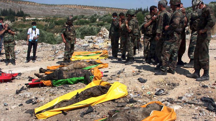 Anlass oder Vorwand für die Offensive? Syrische Soldaten mit Leichen der 120 Sicherheitskräfte, die angeblich von Aufständischen getötet worden sein sollen. Andere Quellen meinen, sie seien als Deserteure von der Armee erschossen worden.