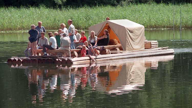 Touristen während einer Floßfahrt auf dem brandenburgischen Oberpfuhlsee bei Lychen.