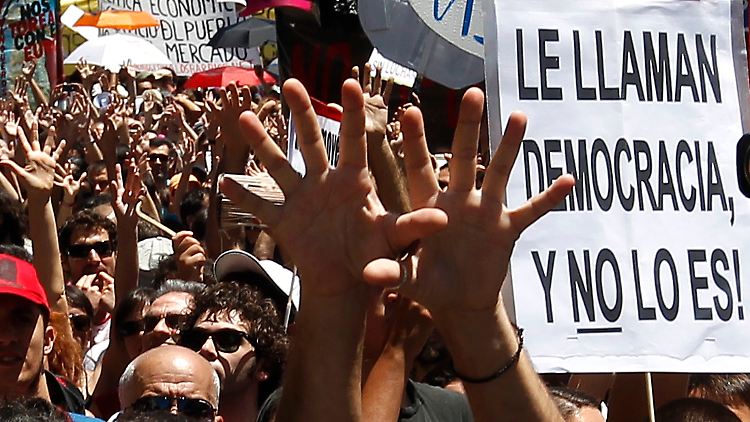 "Sie nennen es Demokratie, aber es ist keine", heißt es auf einem Spruchband in Madrid.