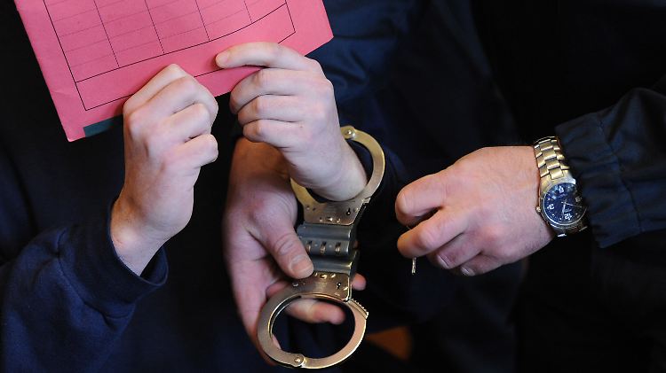 In Handschellen wird der Angeklagte ins Gericht geführt.