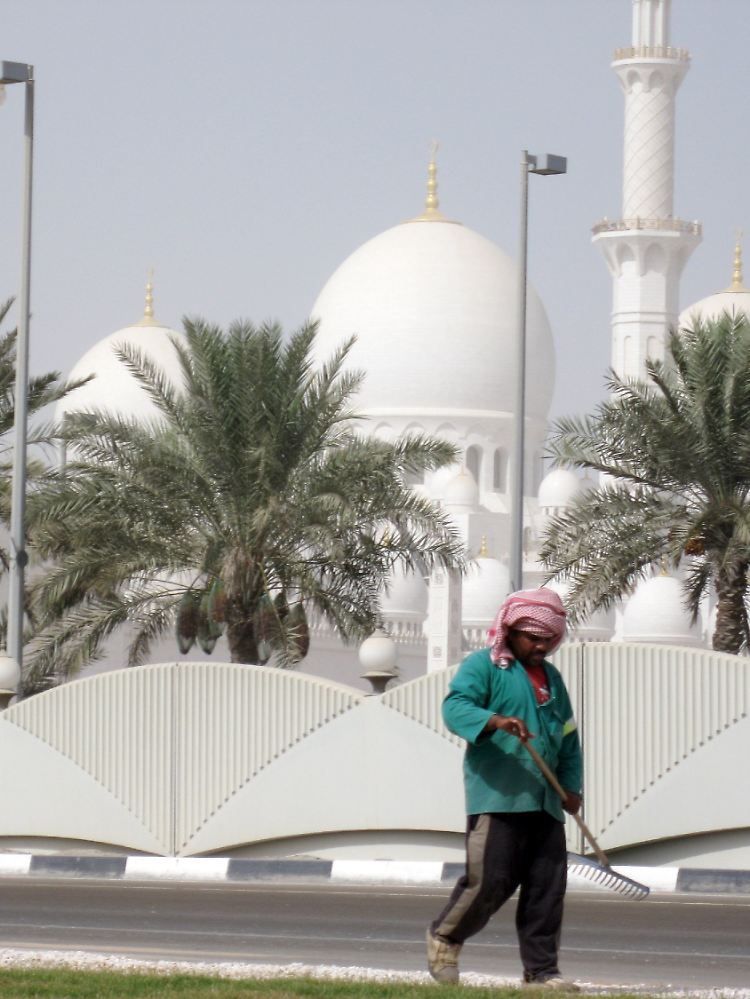 Ein ausländischer Arbeiter kümmert sich darum, dass die Straße vor der Scheich-Said-Moschee in Abu Dhabi sauber ist.