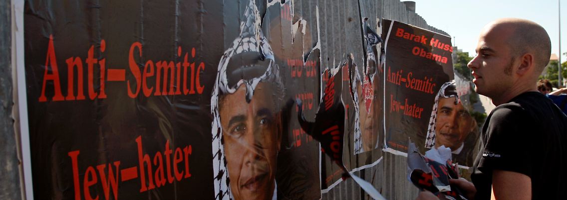 In der Frage der Siedlungspolitik ging Netanjahu nicht auf Forderungen von Obama ein. (Ein Israeli reißt in Jerusalem Plakate ab, auf denen Obama als "Antisemit" und "Judenhasser" diffamiert wird.)