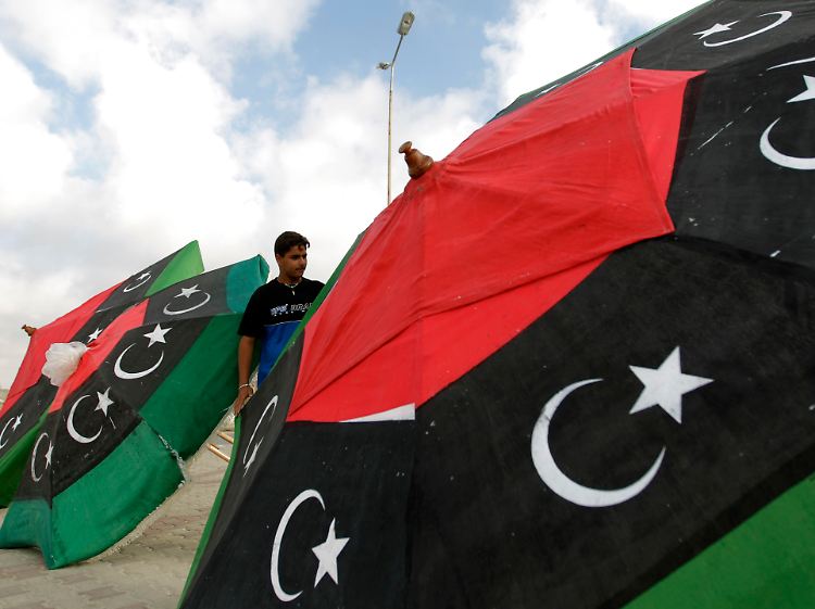 In Bengasi kontrolliert ein Mann Sonnenschirme in den alten Farben des libyschen Königshauses, die auch die Rebellen verwenden.