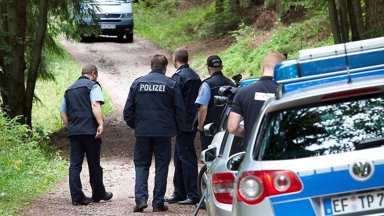 Polizisten sichern den Fundort der Leiche weiträumig ab.