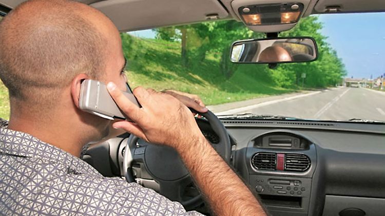 Nicht gerade konzentrationsfördernd: Mit dem Handy am Steuer im Straßenverkehr.