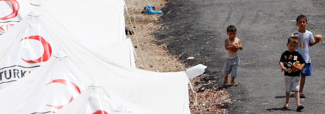 Kinder tragen in einem Flüchtlingscamp in der Türkei Brot. In den Lagern an der Grenze zu Syrien harren Tausende Menschen aus.