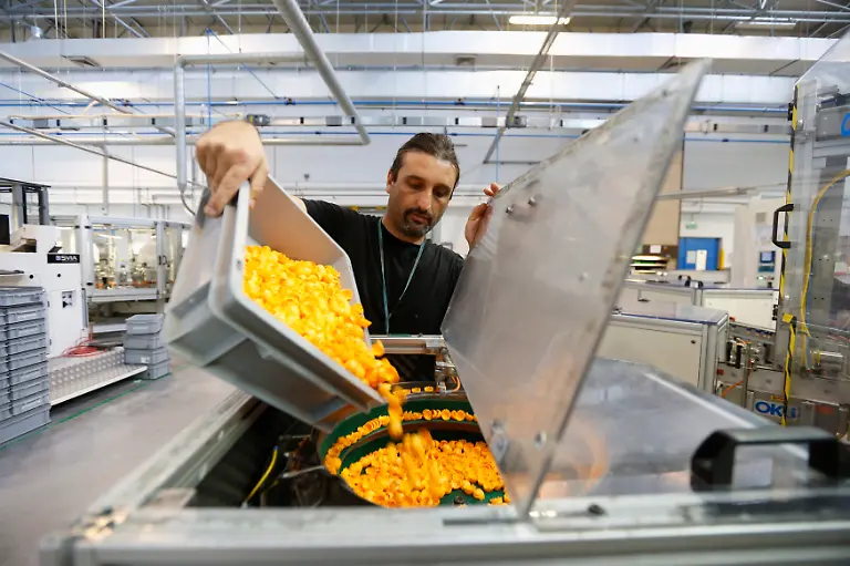 An-employee-pours-Playmobil-figure-hair-pieces-into-an-assembly-machine-at-the-Playmobil-Malta-factory-in-the-Hal-Far-Industrial-Estate-outside-Valletta