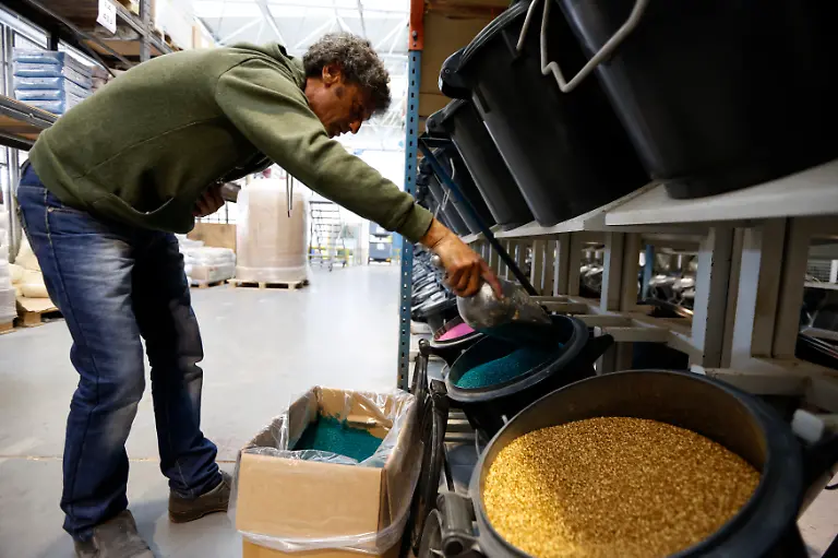 An-employee-fills-containers-with-different-coloured-pigments-used-in-the-production-of-Playmobil-figures-at-the-Playmobil-Malta-factory
