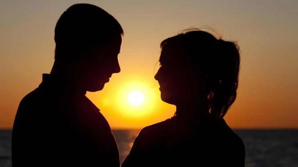 Ein-Paar-steht-bei-Sonnenuntergang-am-Ostseestrand-von-Warnemuende