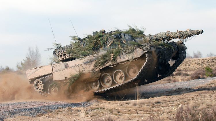 Kampfpanzer vom Typ Leopard 2 in voller Fahrt auf einem Testgelände.
