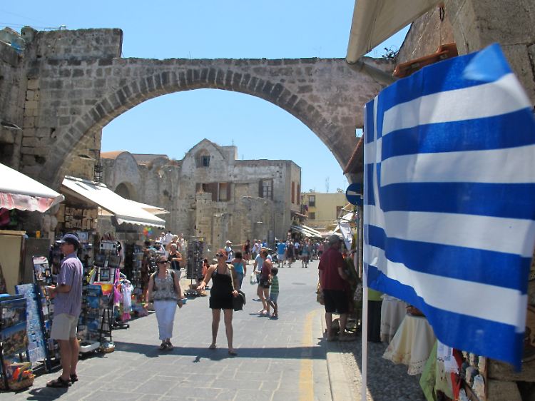 Von den Bildern aus Athen lassen sich Urlauber bislang nicht abschrecken - in Ferienorten wie Rhodos-Stadt bummeln Touristen wie eh und je durch die Gassen.