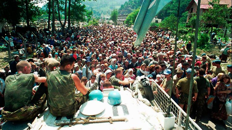 13. Juli 1995: Niederländische Blauhelme schauen zu, wie sich verzweifelte Flüchtlinge aus Srebrenica sammeln.