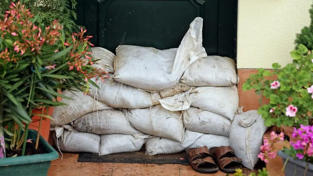 Sandsaecke-vor-einer-Haustuer-Wer-noch-kann-sollte-Moebel-und-Geraete-wegschaffen-oder-in-sichere-Raeume-in-hoeheren-Stockwerken-bringen