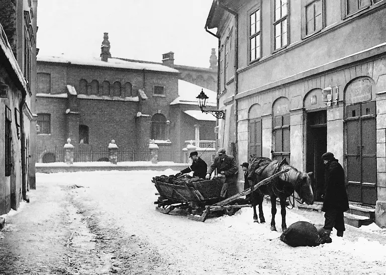 This-is-part-of-a-Jewish-ghetto-in-Krakow-with-the-14th-century-synagogue-in-the-background-Jews-load-coals-from-a-sled-seen-March-5-1940