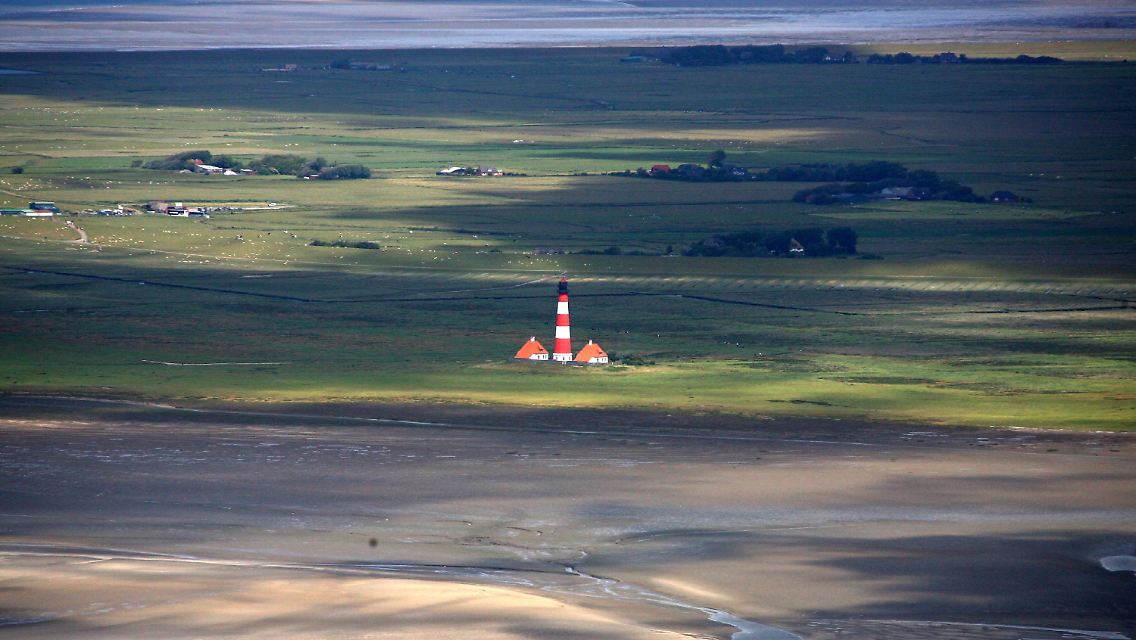 Das Wattenmeer hat gute Chancen auf den Welterbe-Titel: Blick bei Niedrigwasser auf den Leuchtturm von Westerhever an der schleswig-holsteinischen Nordseeküste.