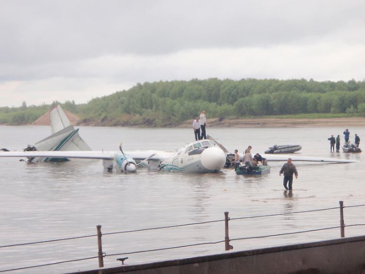 Helfer suchen an der Unglückstelle nach Opfern: Für die An-24 war die Landung zu hart.