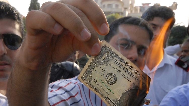 Zeichen der Feindlichkeit: Ein Demonstrant verbrennt einen Dollarschein.