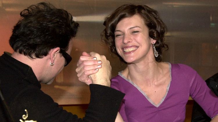 Die Schauspielerin Milla Jovovich beim Armdrücken mit U2-Sänger Bono.