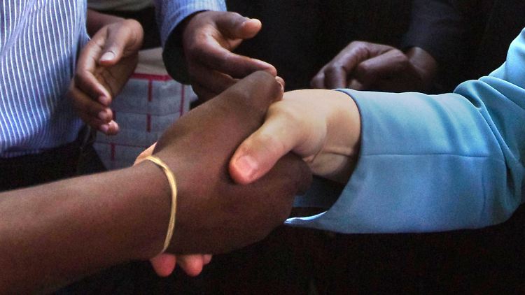 Die Kanzlerin wird in Kenia von einem Studenten begrüßt.