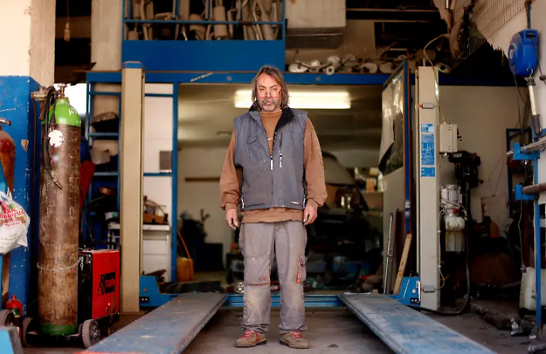 George-Kanlopoulos-55-a-guide-mechanic-and-hotelier-poses-for-a-picture-in-his-garage-at-the-town-of-Sparta-in-the-Peloponnese-area-of-Greece-March-20-2012-When-asked-how-he-had-been-affected-by-the-economic-crisis-Kanlopoulos-replied-I-haven-t-been-affected-as-much-as-others-because-I-am-a-mountain-guide-as-well-as-a-mechanic-and-hotel-owner-This-means-I-have-more-options