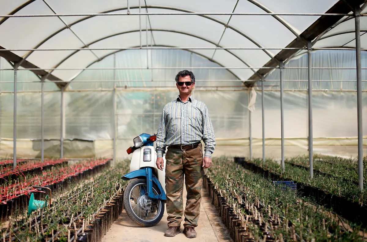 Michalis-Kourla-58-a-plant-nursery-owner-poses-for-a-picture-in-one-of-his-greenhouses-at-the-village-of-Peristeri-in-the-Peloponnese-area-of-Greece-March-19-2012-When-asked-how-he-had-been-affected-by-the-economic-crisis-Kourla-replied-sales-are-down-slightly-but-generally-we-are-doing-ok-Picture-taken-March-19-2012