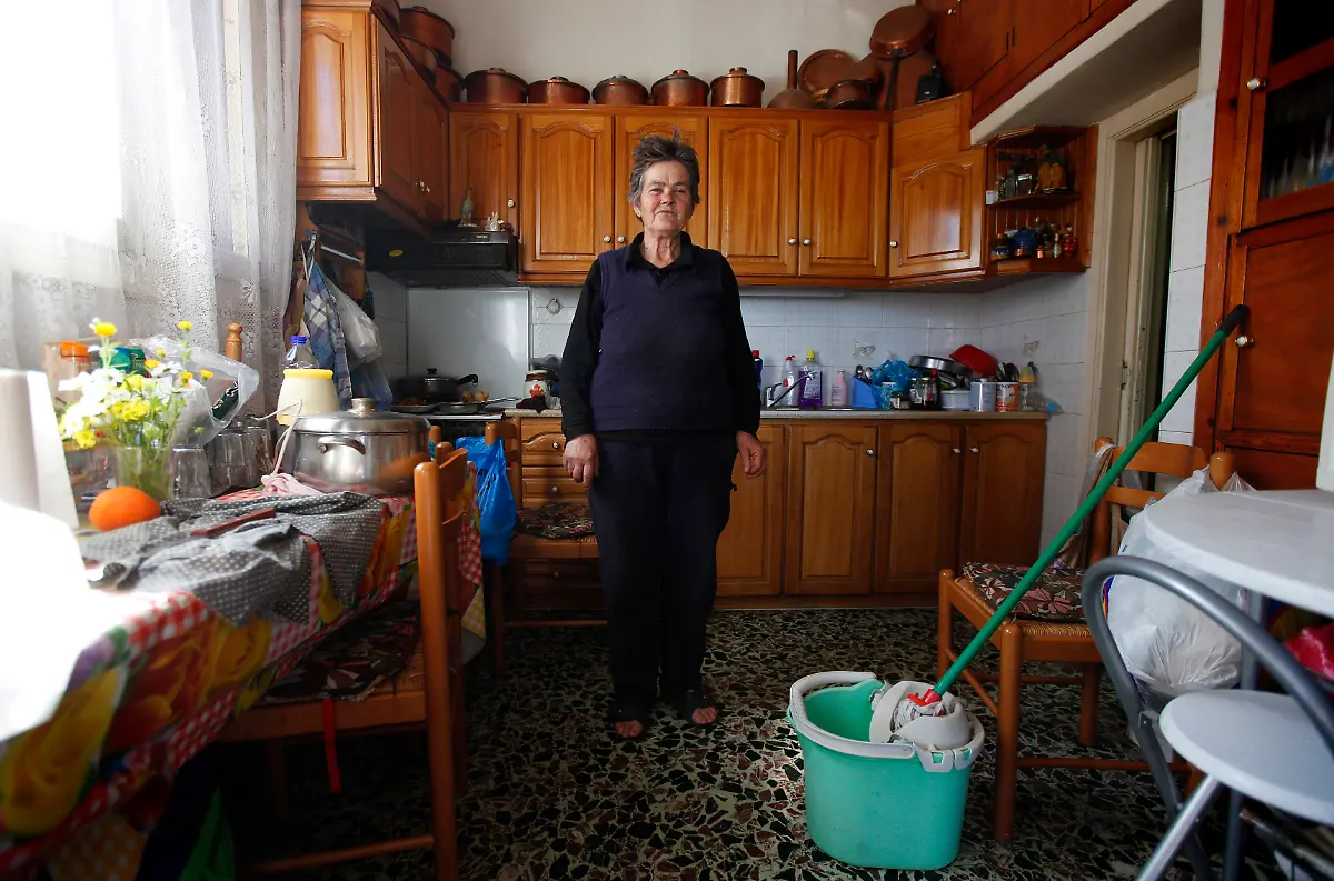Voula-Stamatakos-72-a-housewife-poses-for-a-picture-in-her-home-at-the-village-of-Krokeae-in-the-Peloponnese-area-of-Greece-March-18-2012-When-asked-how-she-had-been-affected-by-the-economic-crisis-Stamatakos-replied-My-pension-has-been-cut-but-I-try-to-stay-positive-Picture-taken-March-18-2012
