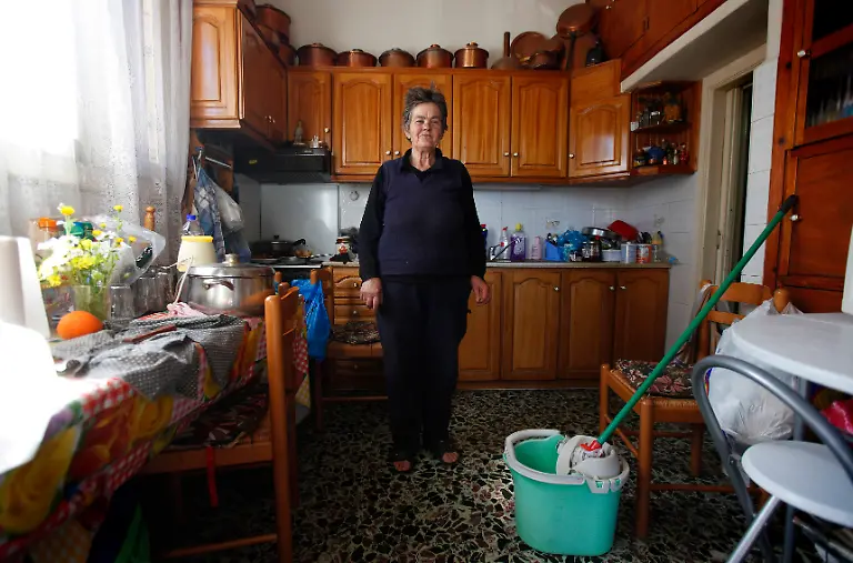 Voula-Stamatakos-72-a-housewife-poses-for-a-picture-in-her-home-at-the-village-of-Krokeae-in-the-Peloponnese-area-of-Greece-March-18-2012-When-asked-how-she-had-been-affected-by-the-economic-crisis-Stamatakos-replied-My-pension-has-been-cut-but-I-try-to-stay-positive-Picture-taken-March-18-2012
