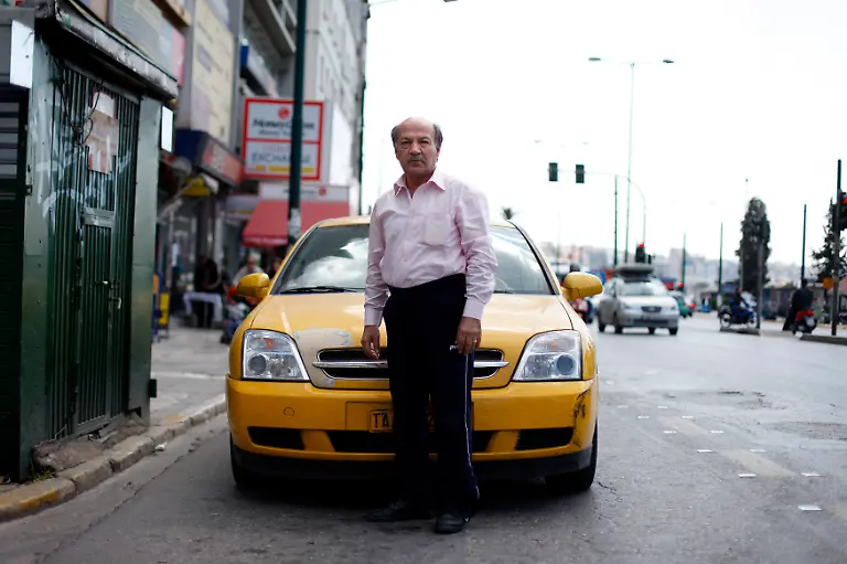 Dasalakis-Theodoros-60-a-taxi-driver-poses-for-a-picture-in-front-of-his-taxi-at-the-port-in-Athens-March-28-2012-When-asked-how-he-had-been-affected-by-the-economic-crisis-Theodoros-replied-I-share-the-taxi-with-my-son-so-we-can-work-24-hours-a-day-between-us-to-make-things-work-Picture-taken-March-28-2012