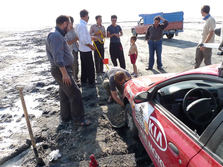 Als der Wagen am Urmia-See in der Salzkruste festhängt, kommen einige Iraner vorbei - um zuzusehen, wie die Brüder die Reifen freischaufeln.