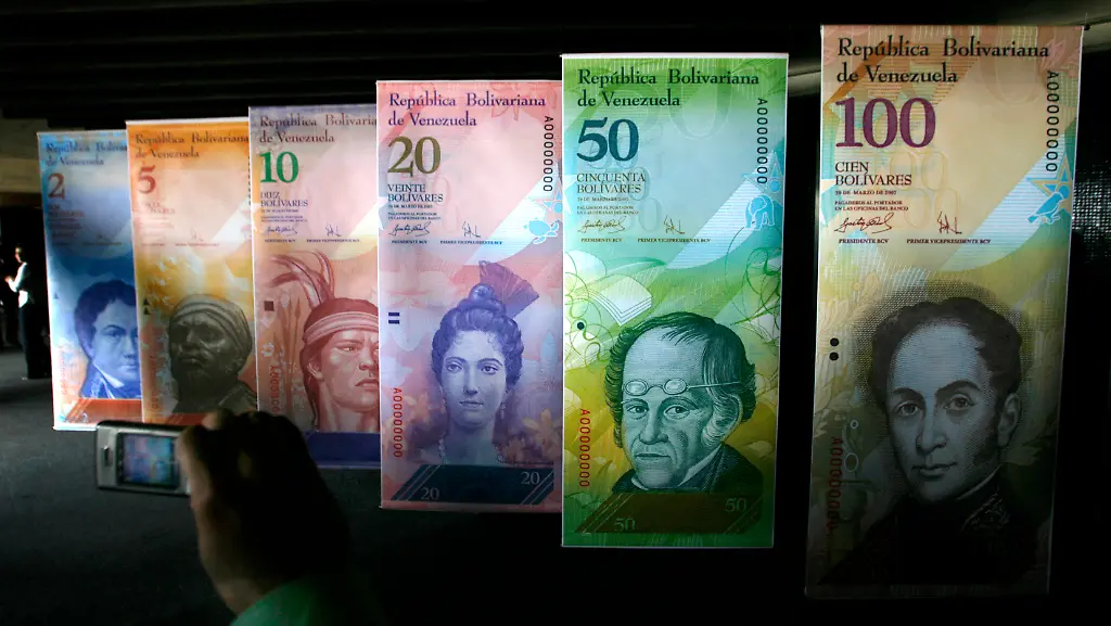 Bolivar-Fuerte-A-man-takes-a-picture-with-his-mobile-phone-of-big-samples-of-a-new-family-of-Venezuelan-notes-at-Central-Bank-headquarters-in-Caracas-October-24-2007-On-January-1-2008-the-national-currency-the-Venezuelan-Bolivar-will-go-through-a-currency-change-to-the-new-Bolivar-Fuerte-which-will-take-three-zeros-from-it-s-current-value-From-Monday-stores-and-businesses-will-be-obliged-to-show-prices-in-both-the-current-Bolivar-and-the-Bolivar-Fuerte