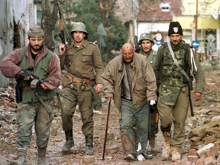 Serbische Soldaten und Freiwillige führen am 18. November 1991 einen Kroaten in in dem zerstörten Vukovar ab.