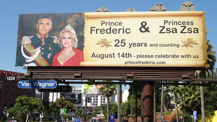 Ein großes Plakat weist auf die Silberhochzeit von Prinz Frederic und Zsa Zsa Gabor hin.