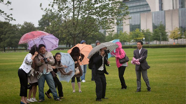 Kommen auch bei Regenwetter: Touristen im Berliner Regierungsviertel.